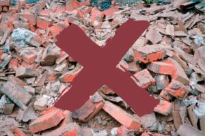 A pile of rubble with a large red X across it.